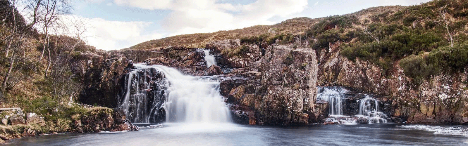 A waterfall surrounded by rocks and trees.